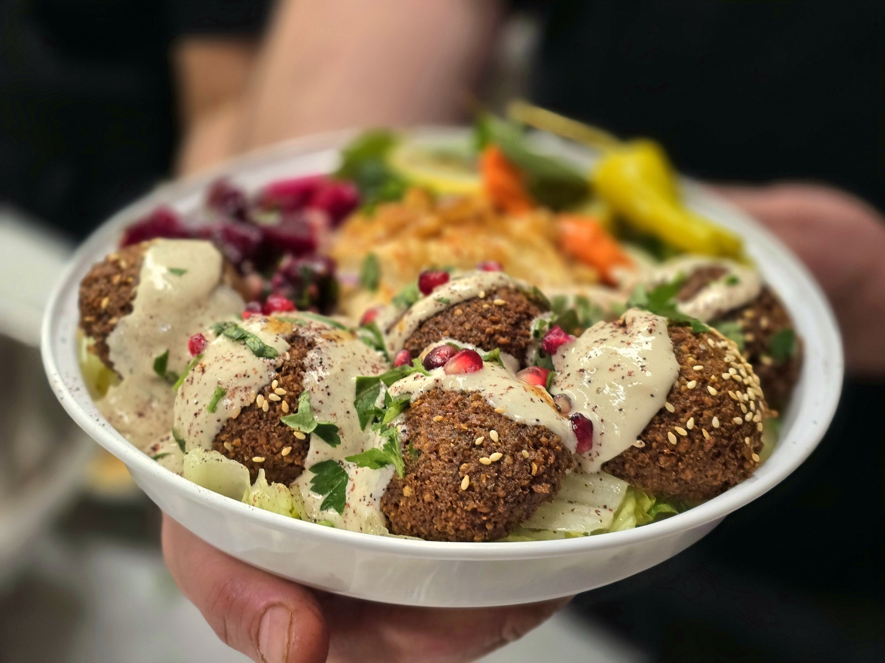 Falafel bowl with hummus, vegetables, and pickles