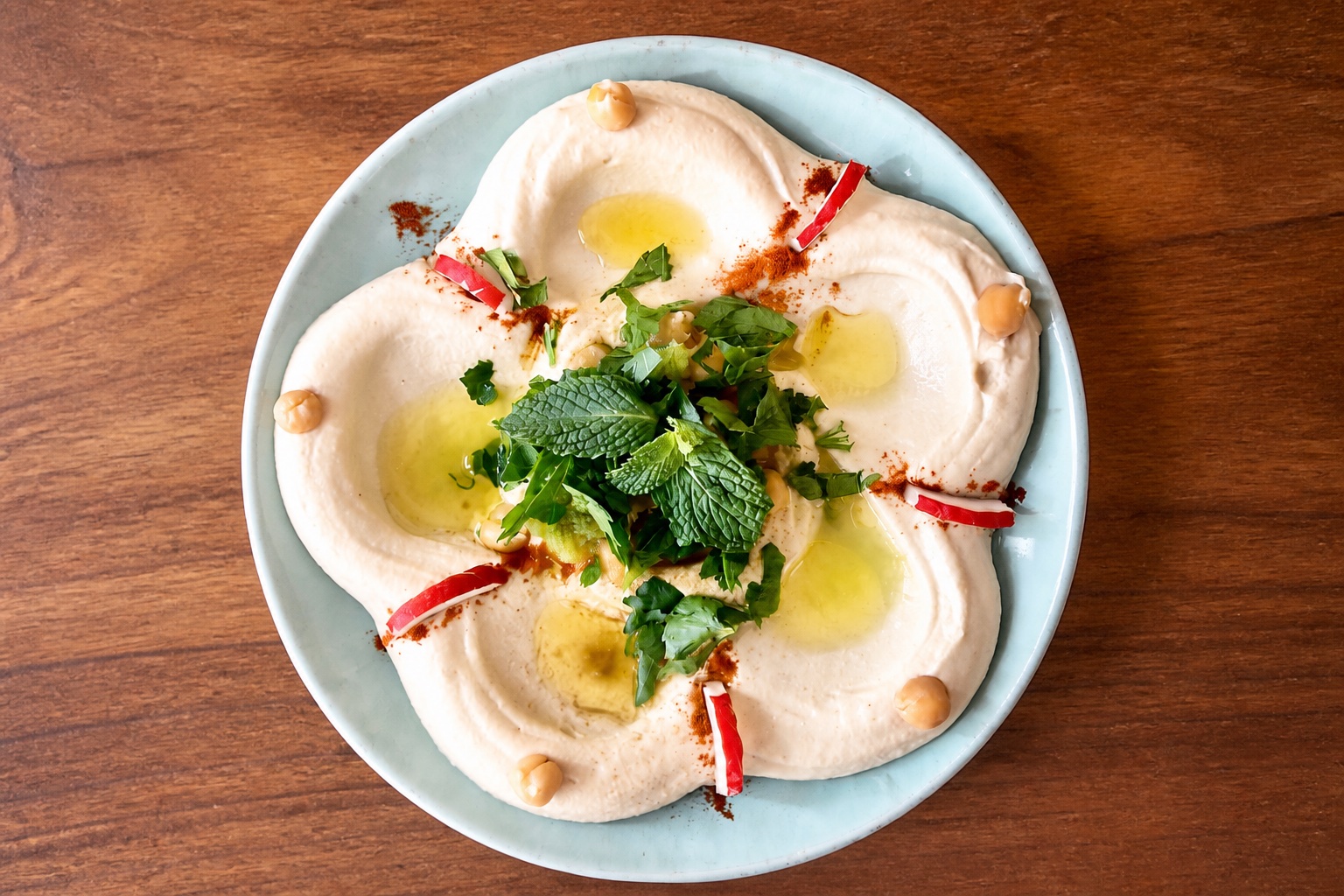 Plate of Georgie's hummus with olive oil and herbs.