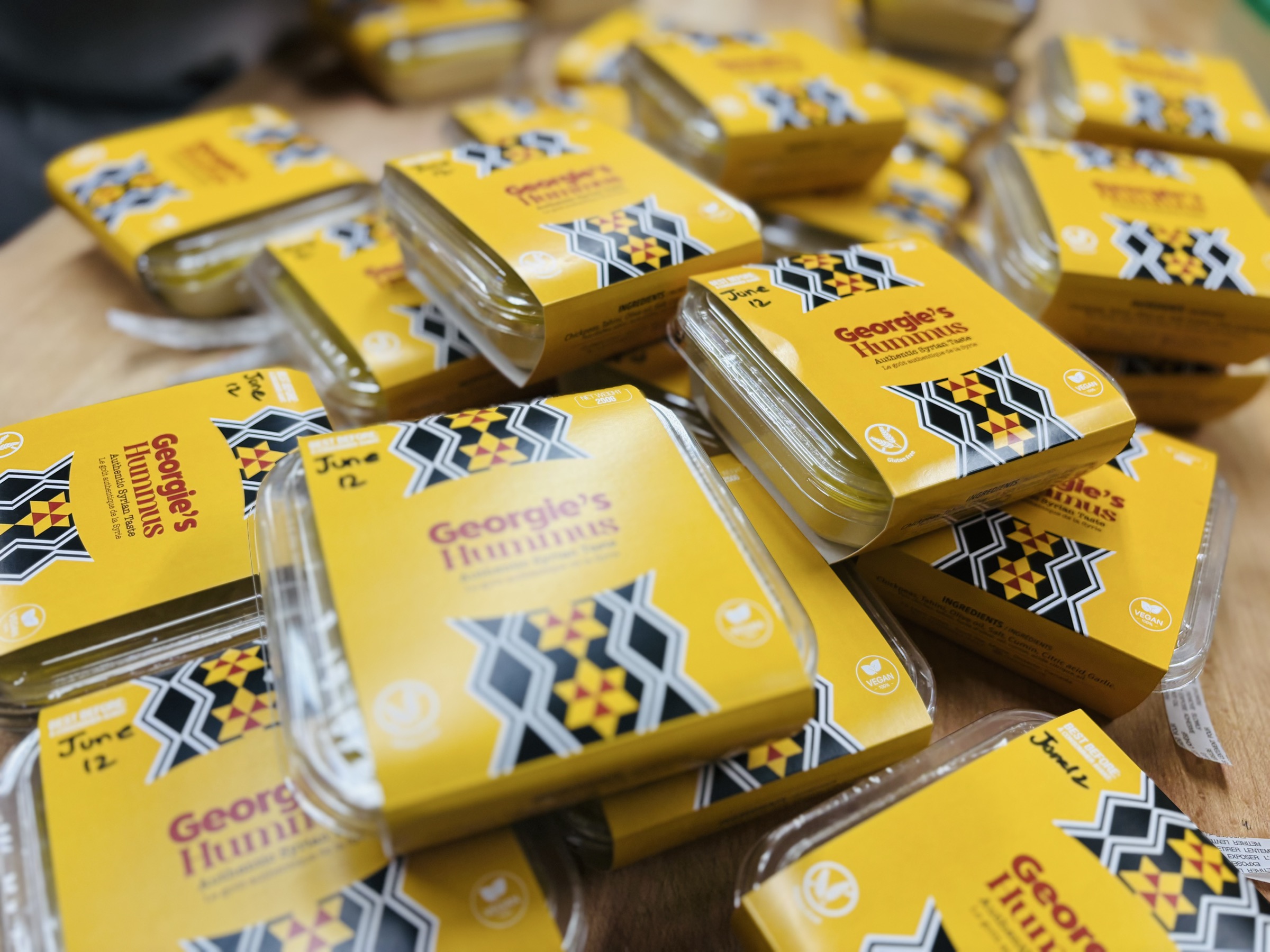 Georgie's packaged hummus containers ready at the counter.