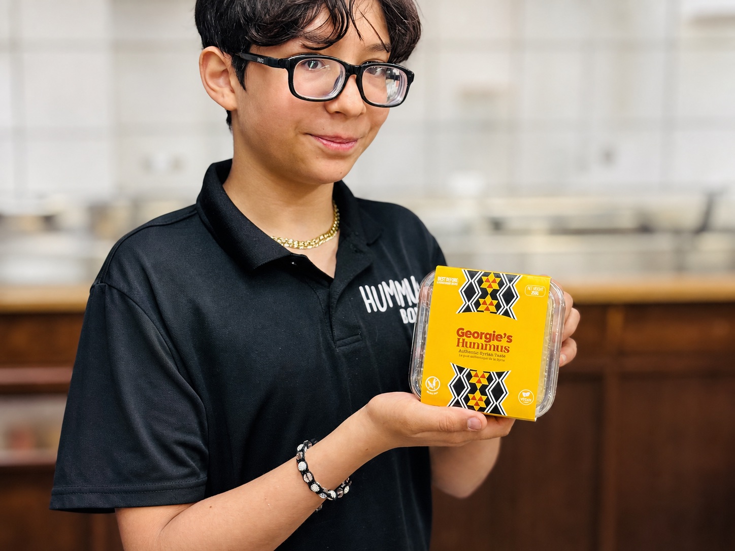 Georgie's team member holding a take-home hummus package.